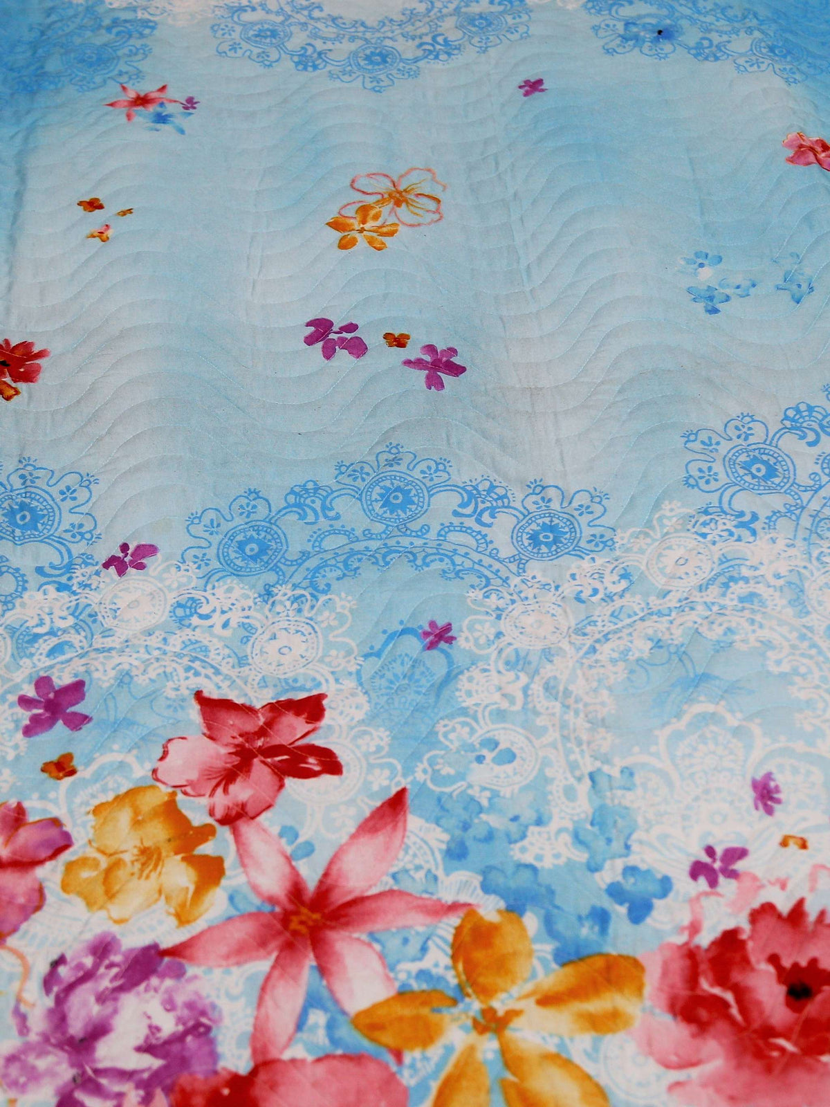 Close-up of pink and orange roses printed on sky blue quilted cotton