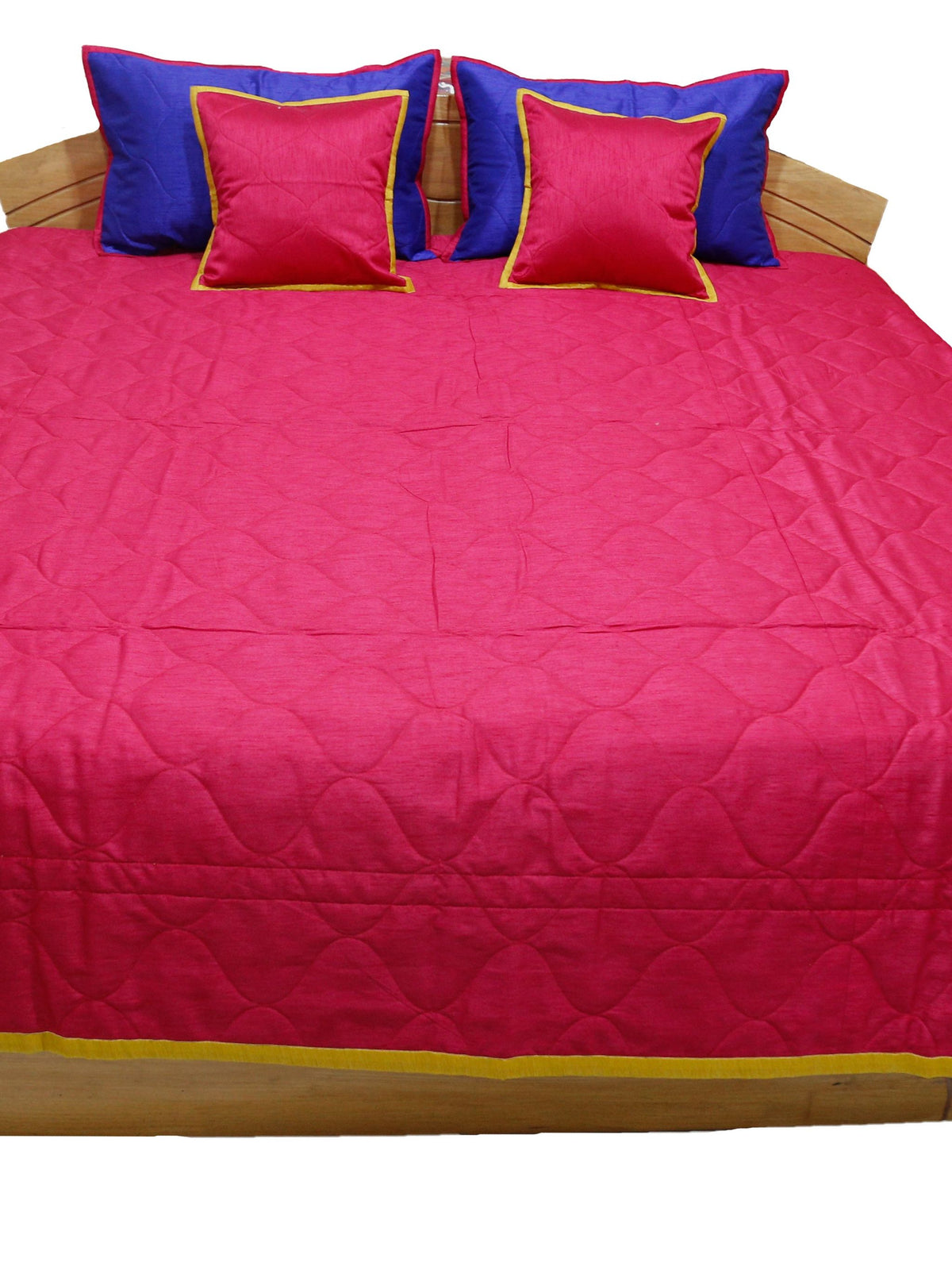 Crimson quilted side laid flat with blue and crimson gold edged cushion covers