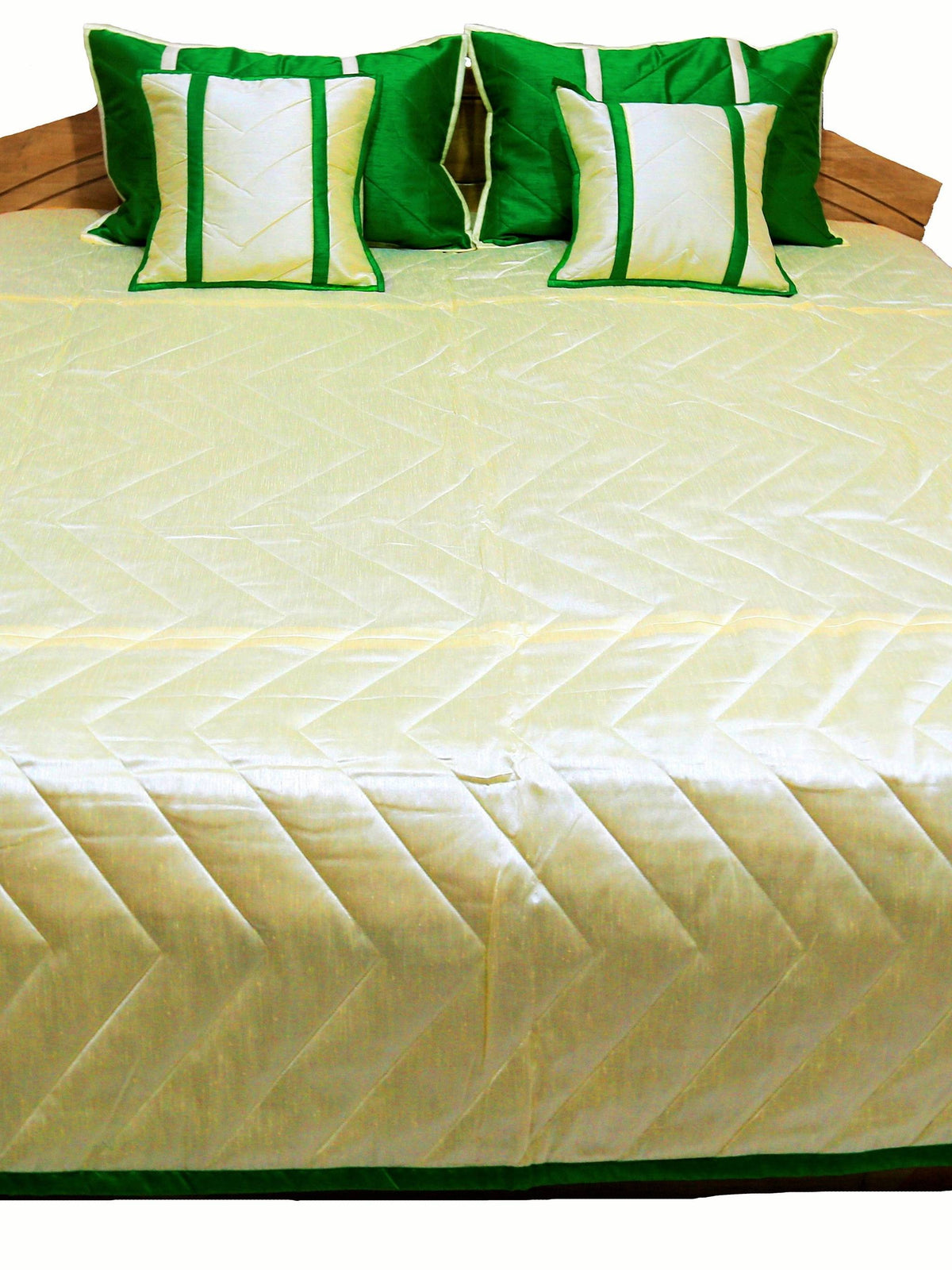Cream quilted side laid flat with green border and cream and green cushions