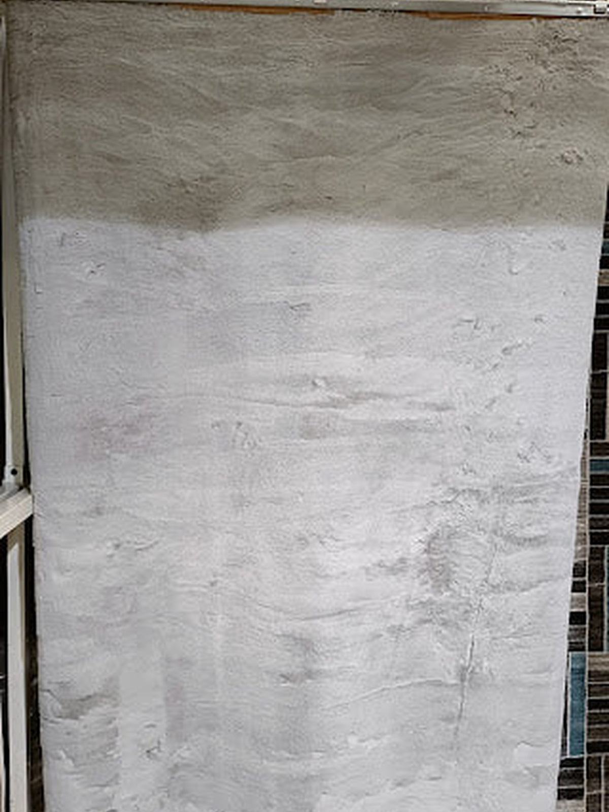Pale grey artificial fur rug with a long, soft pile