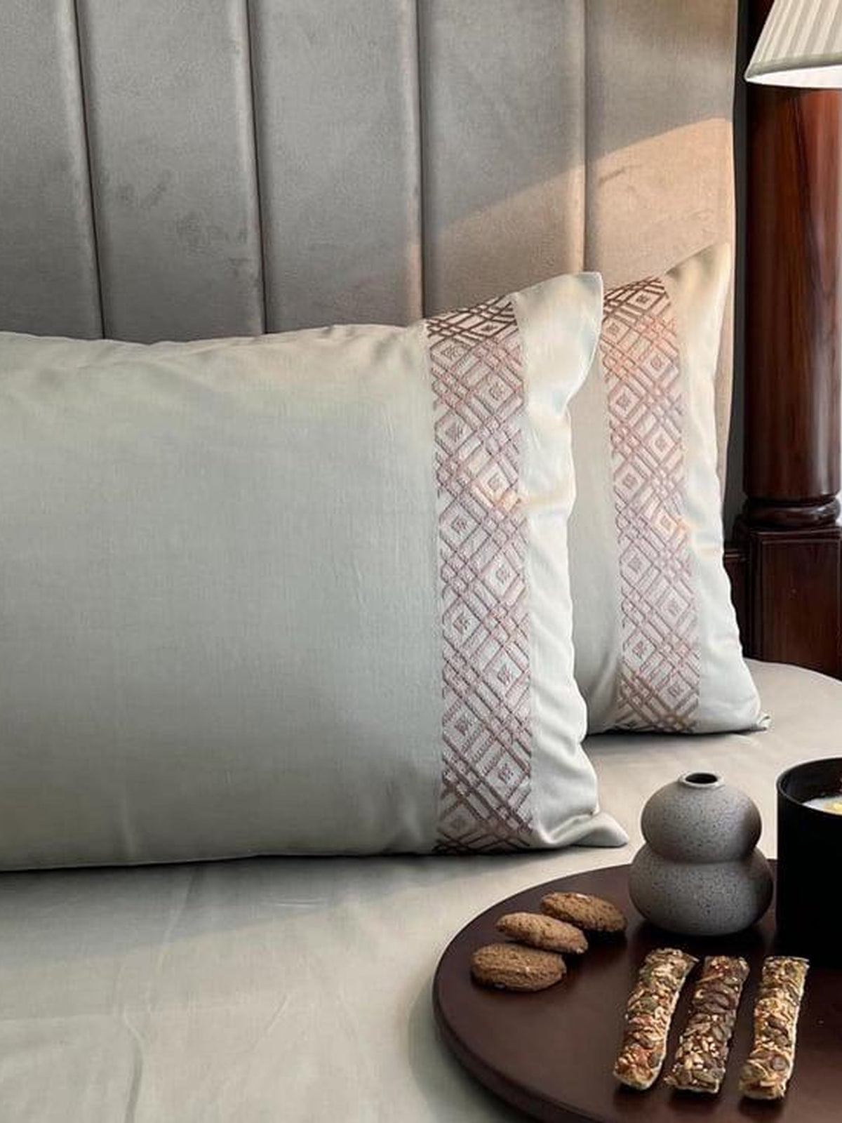 Close up of a cream pillow with a rose embroidered band, Beige Classic Collection