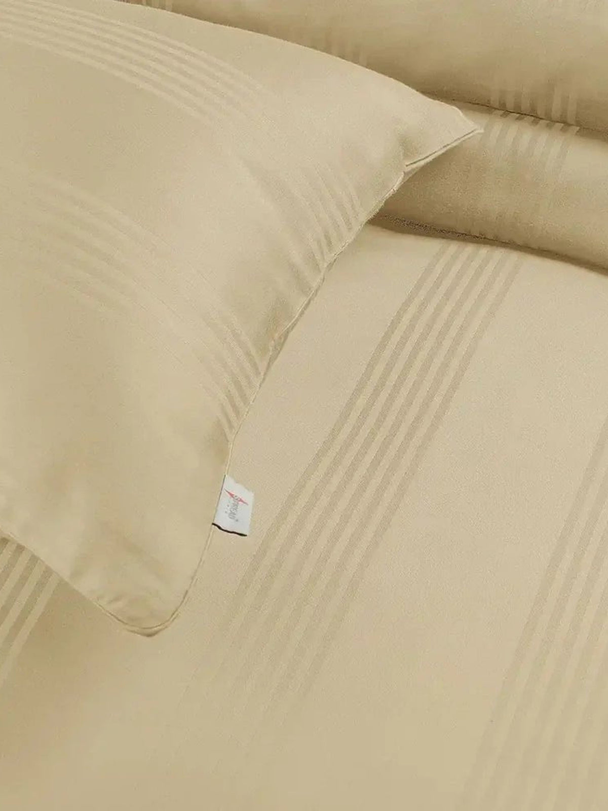 Close-up of a pale butter cream satin stripe pillow cover and sheet