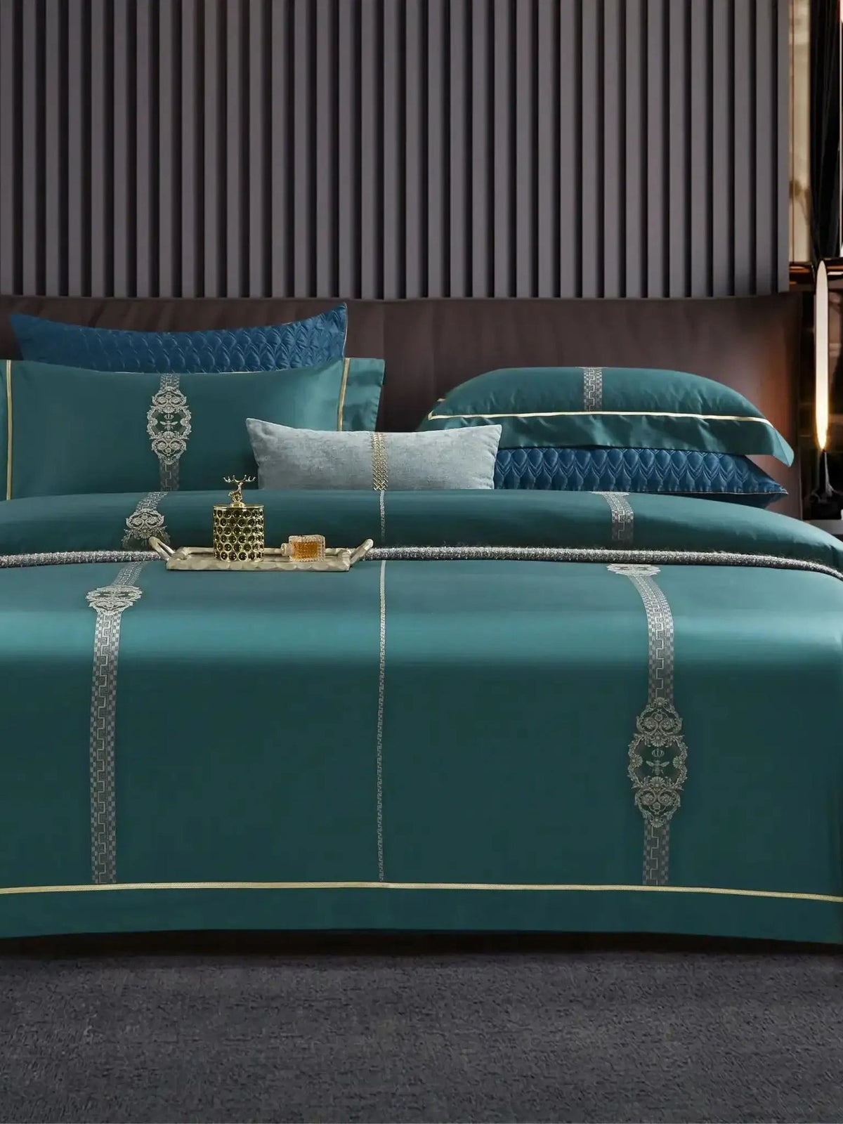 Teal jacquard bedsheet set with a gold embroidered trim, styled on a bed with navy blue pillow covers