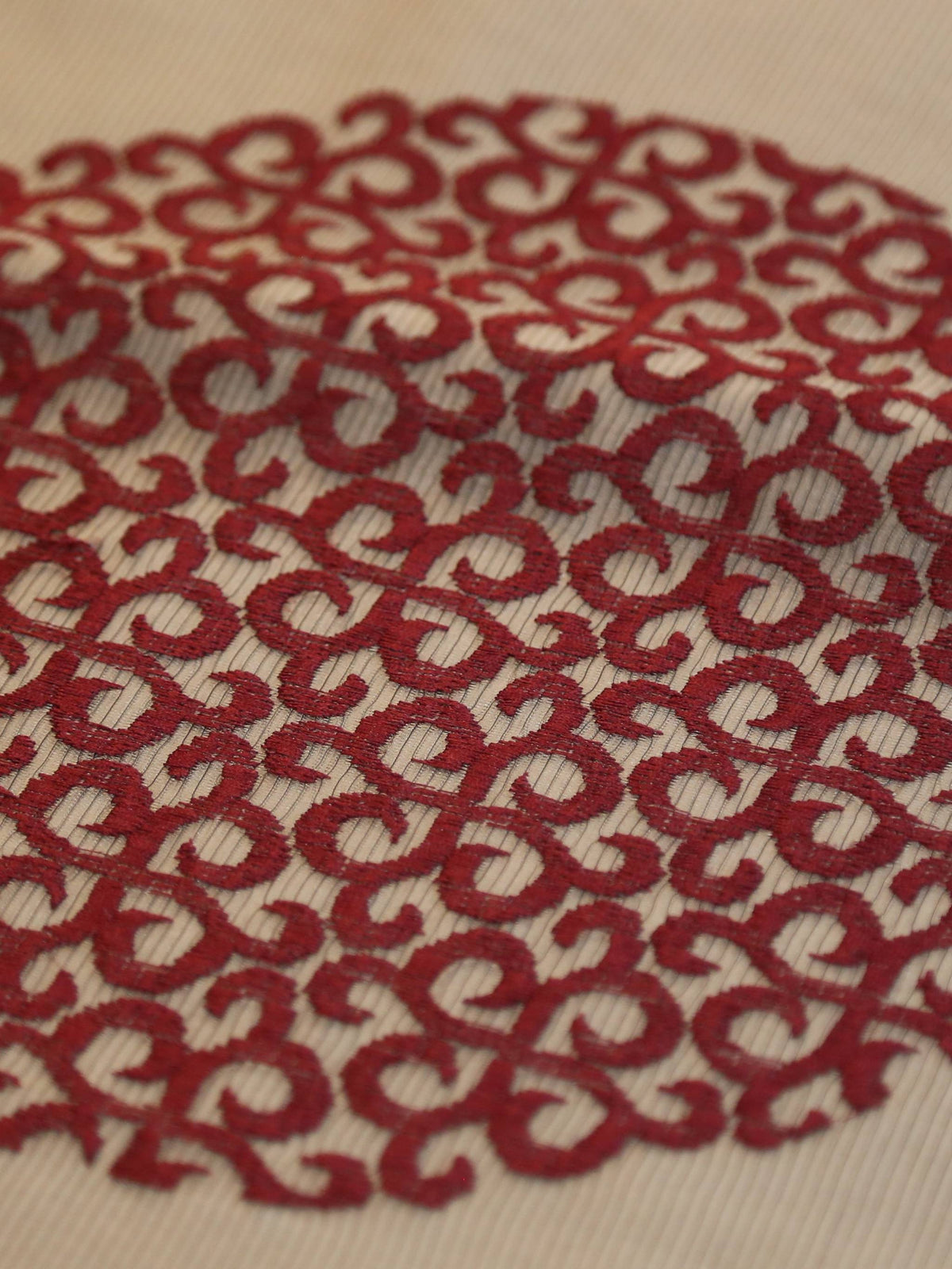 White oval table cover with a maroon circular medallion print and a solid maroon border