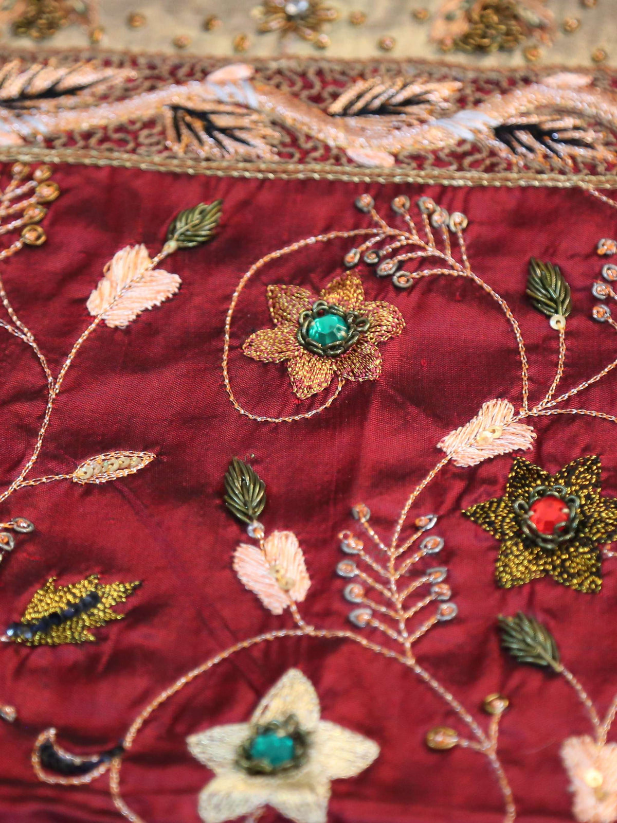 Maroon silk table cover with a gold-bordered floral embroidered runner panel down the centre