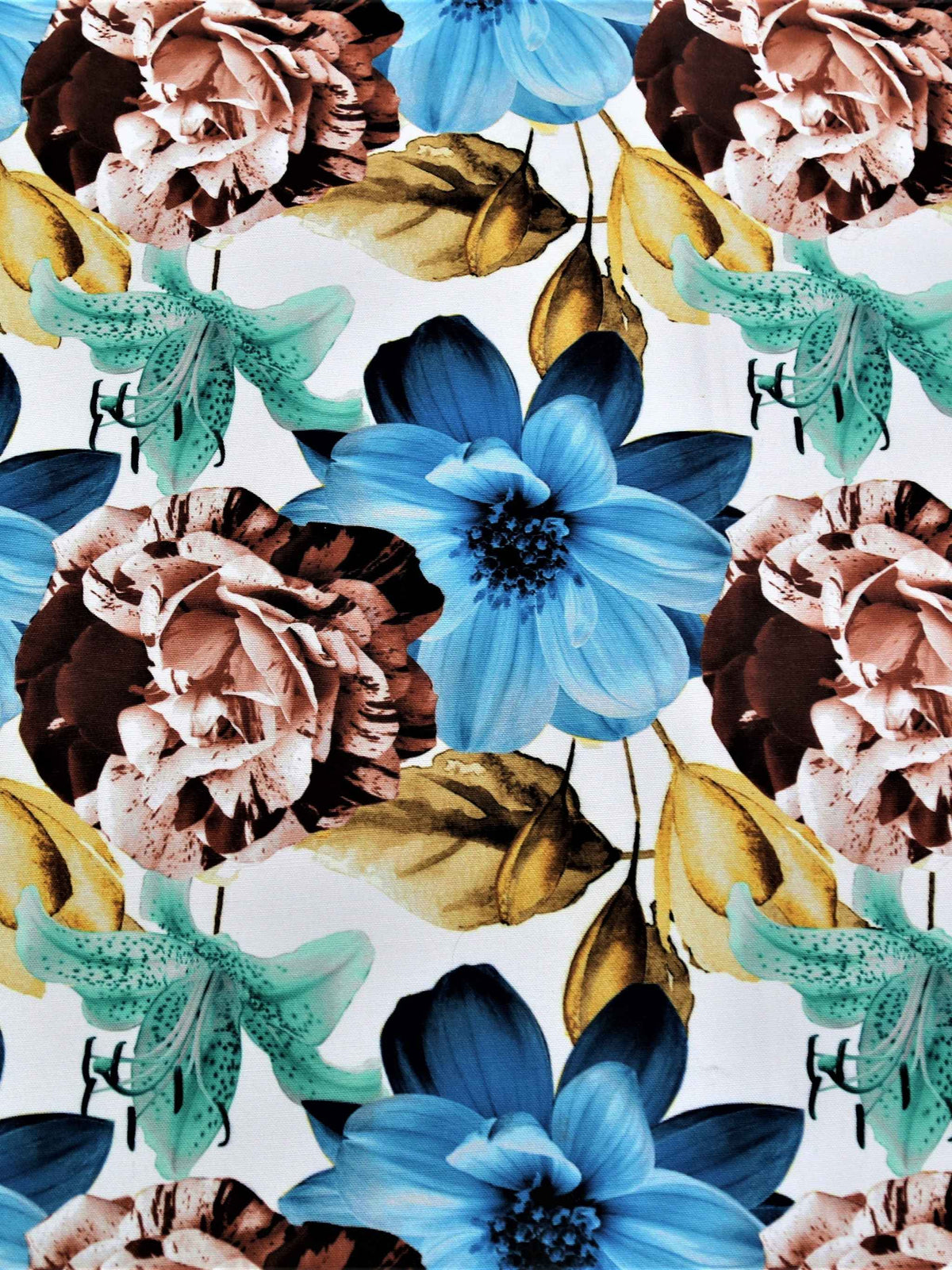 White table cover with a large blue, brown, and teal floral print and a solid light-blue underskirt with gold piping