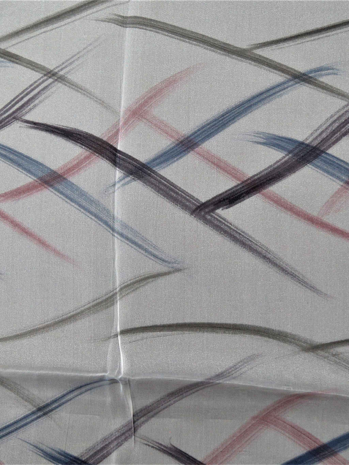 White table cover with a criss-crossing blue, pink, and grey stitch-line pattern and a solid blush-pink satin border