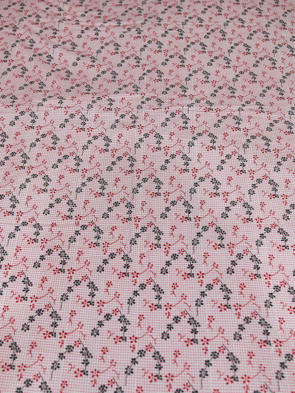 Close-up of small pink and green floral sprigs printed on the dusty pink dohar