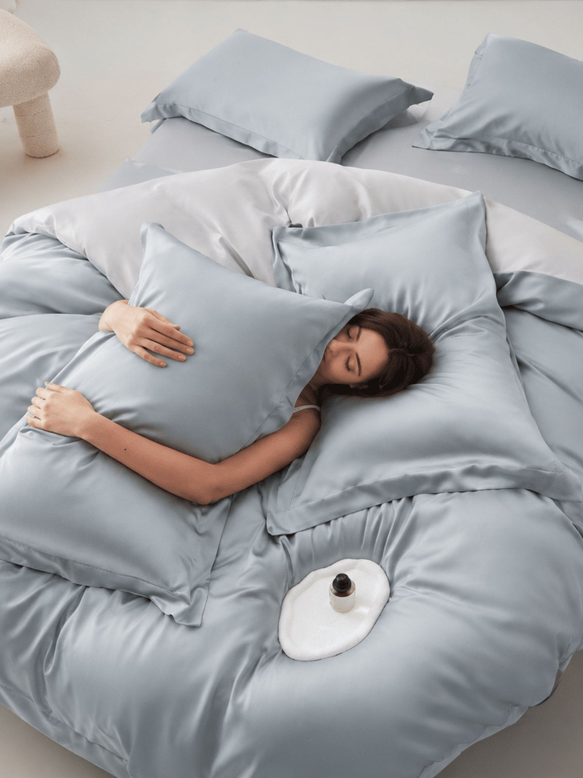 Pale blue-grey Tencel bedding set with duvet cover, made up on a bed