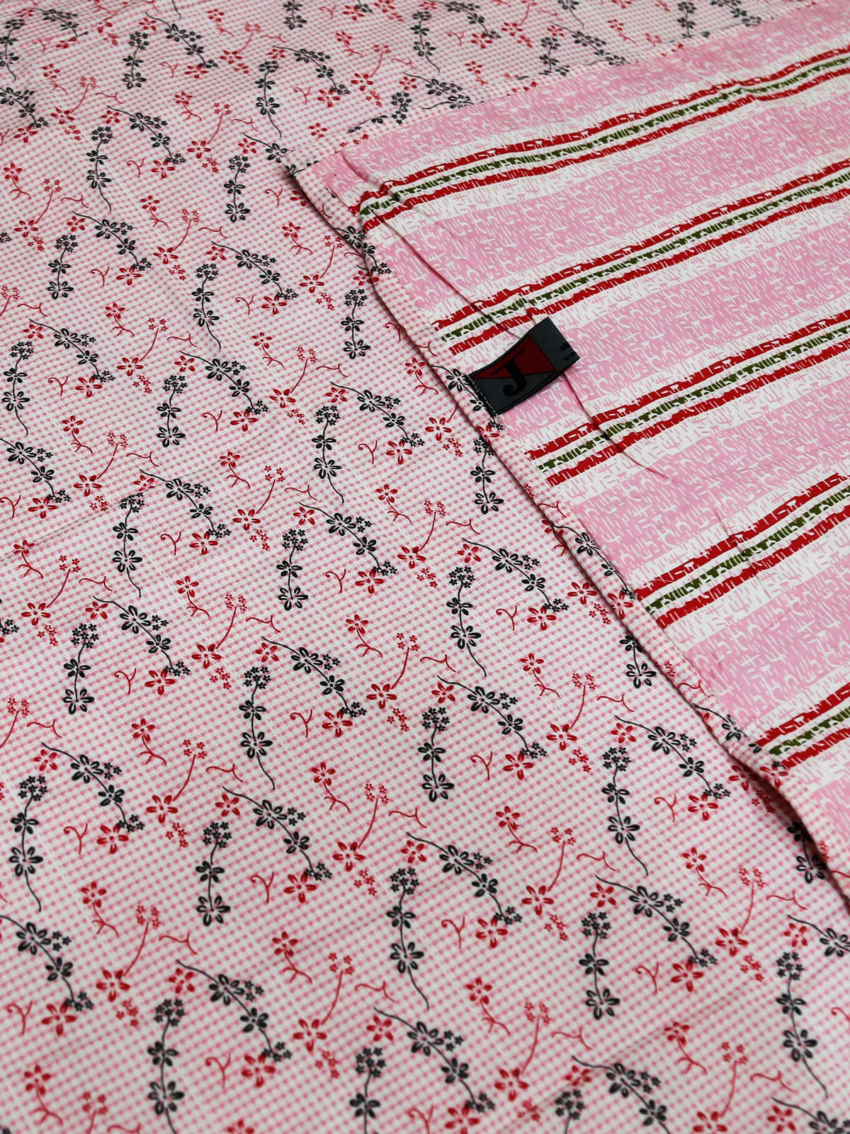 Close-up of the printed field meeting the woven pink and green striped border