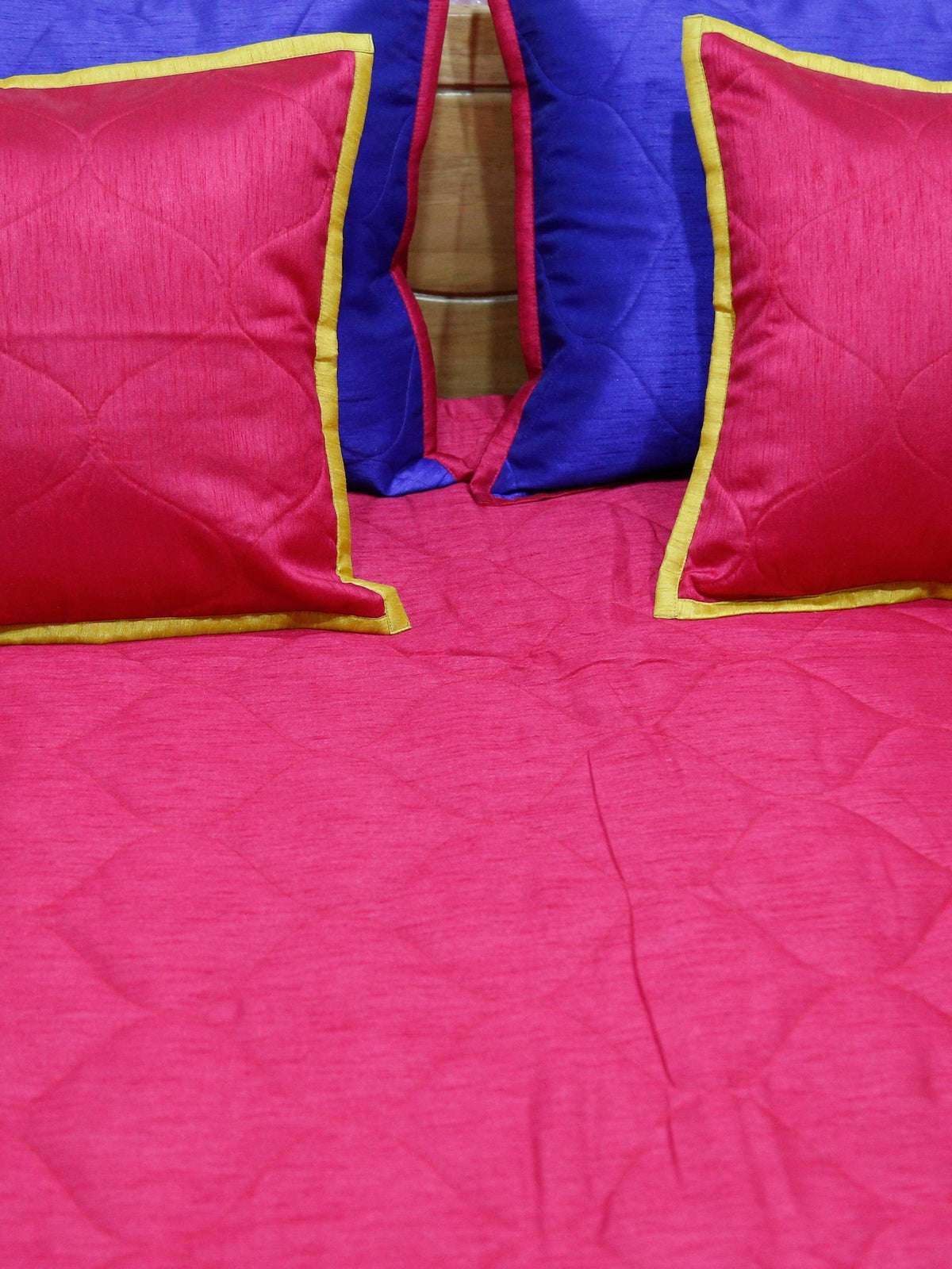 Close-up of crimson cushion covers on the crimson quilted side