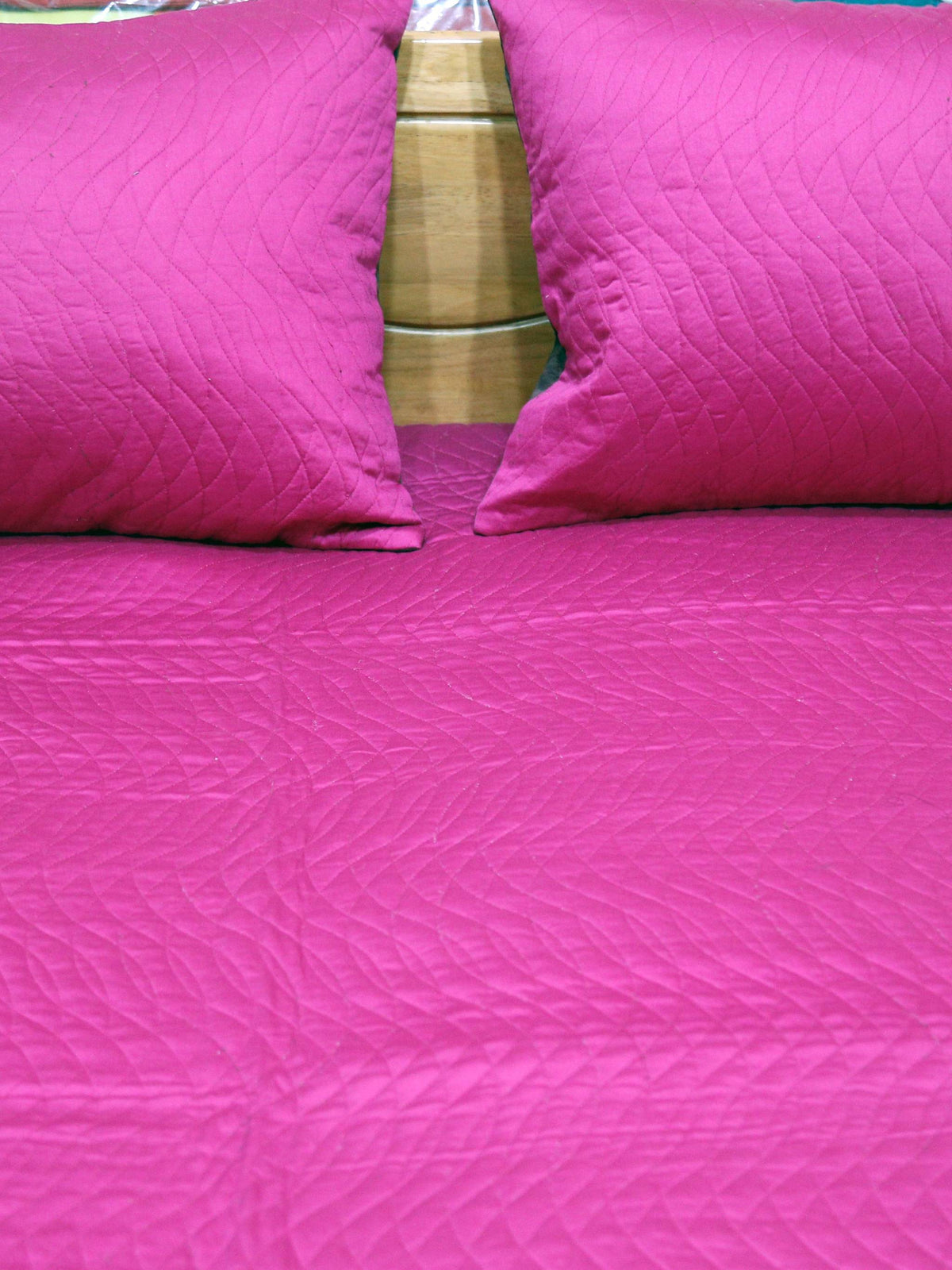 Close-up of magenta pillow covers on the magenta quilted side