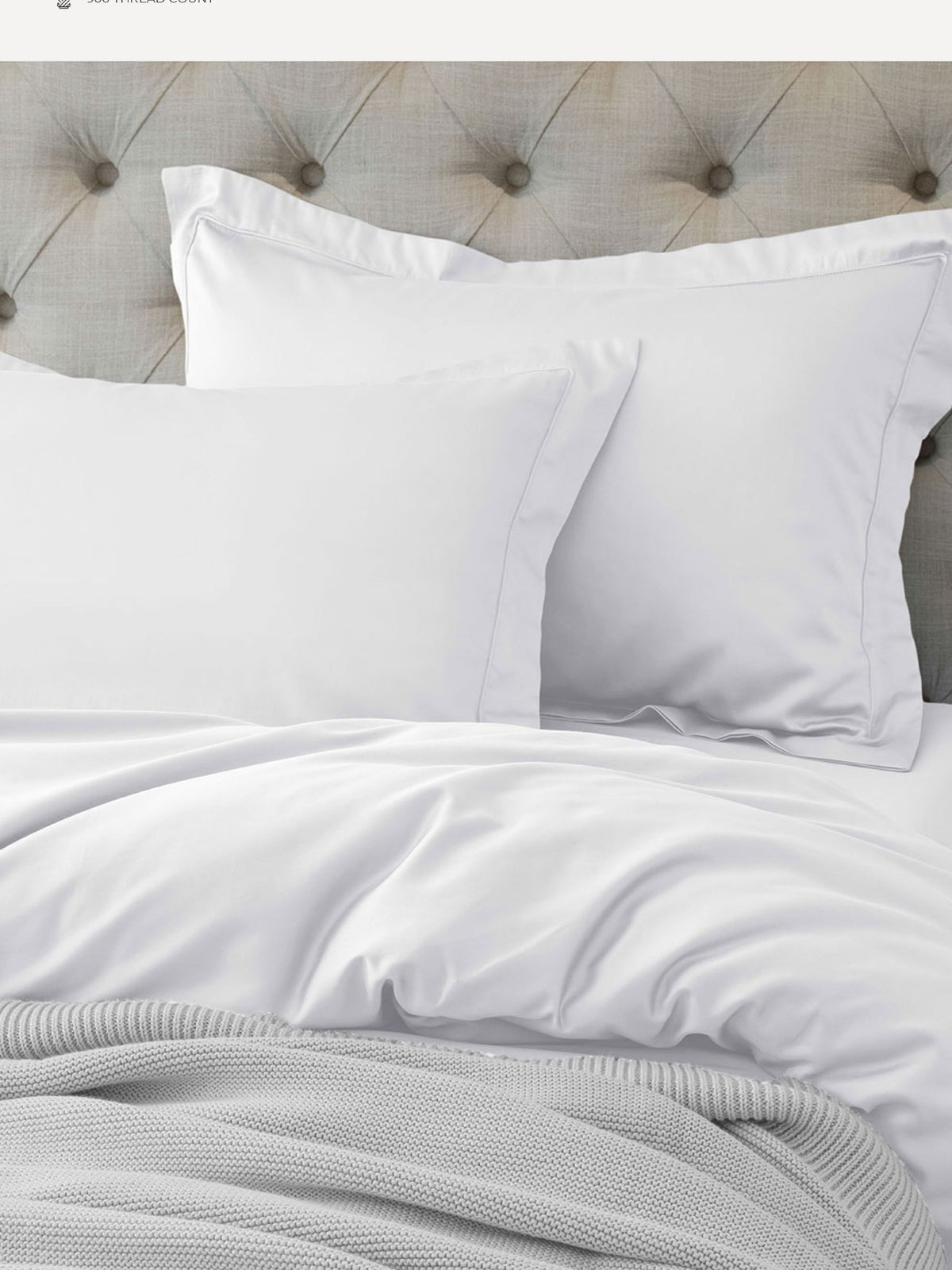 White Supima cotton bedding with oxford pillows and a grey waffle throw