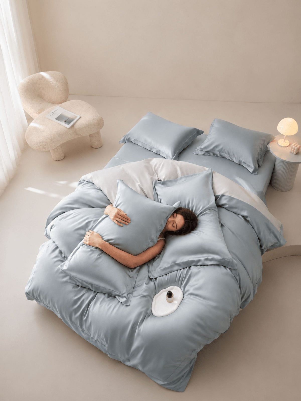 Pale blue-grey Tencel bedding set with duvet cover, made up in a bright bedroom