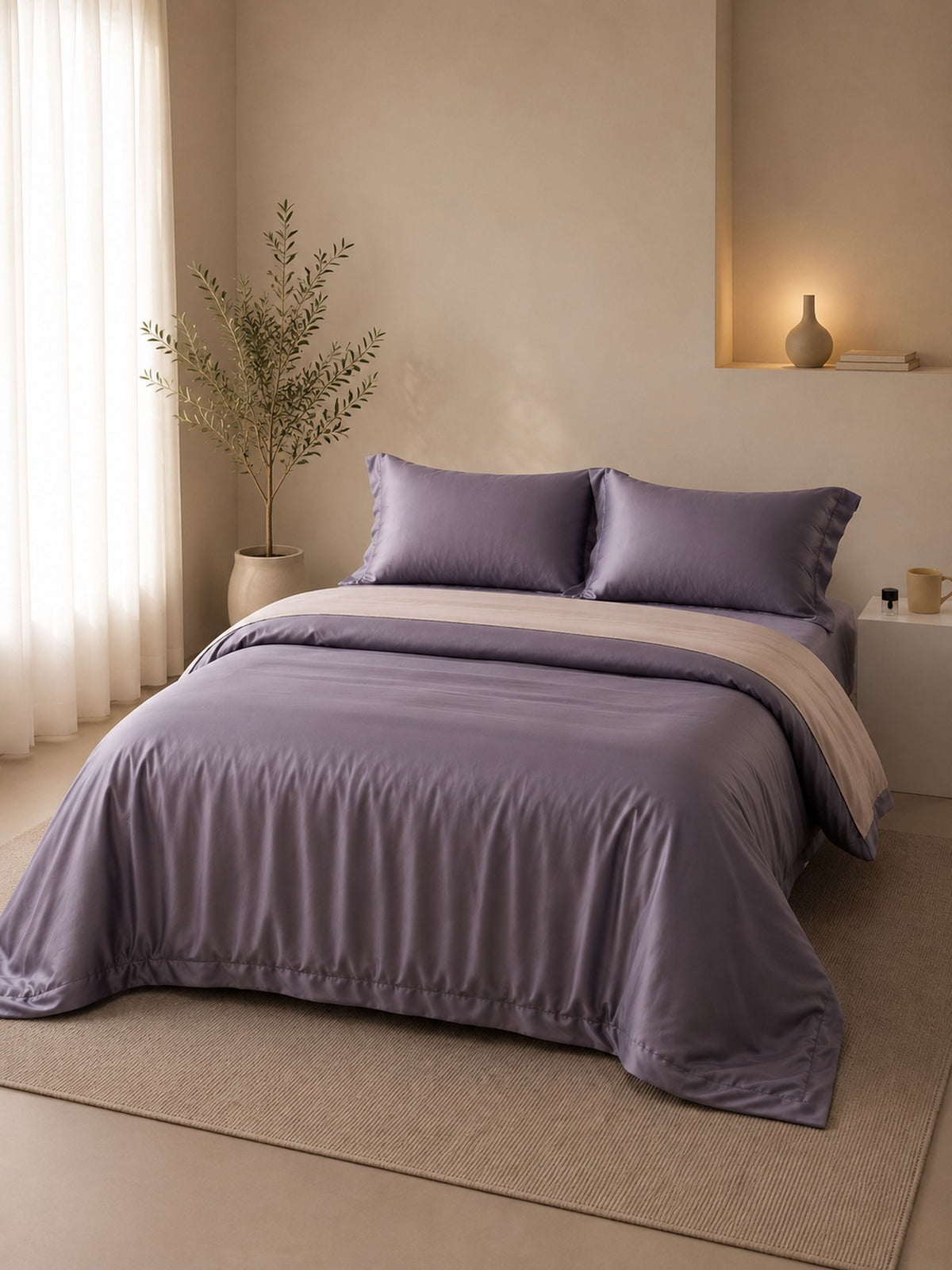 Charcoal mauve Tencel bedding set with a cream reverse, made up on a bed