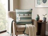 Green and white striped cotton cushion cover with contrast piping displayed on a beige accent chair