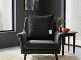 Black textured woven cushion cover with beige geometric detailing placed on a modern armchair