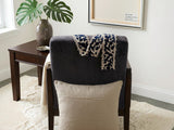Beige cushion cover with detachable black patterned accent strip