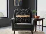 Black textured woven cushion cover with beige geometric detailing placed on a modern armchair
