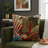 Tropical botanical printed cotton cushion cover featuring colorful leaves and floral motifs on a sofa