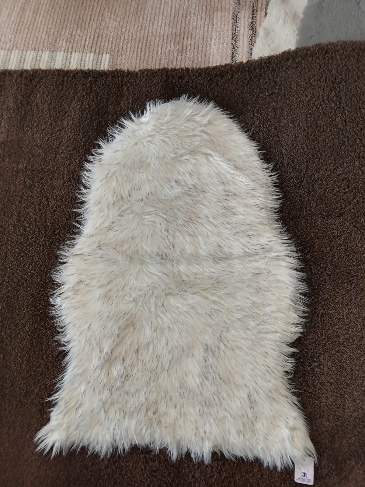 Cream faux sheepskin bedside runner with a long shaggy pile