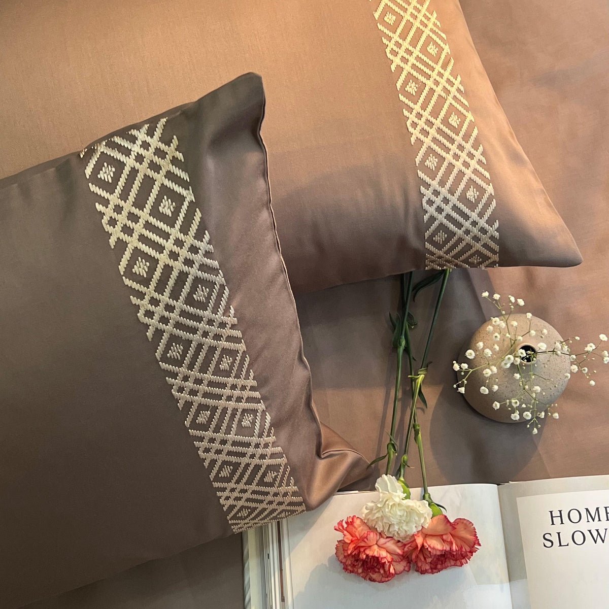 Taupe bedding with white geometric diamond embroidered pillow borders