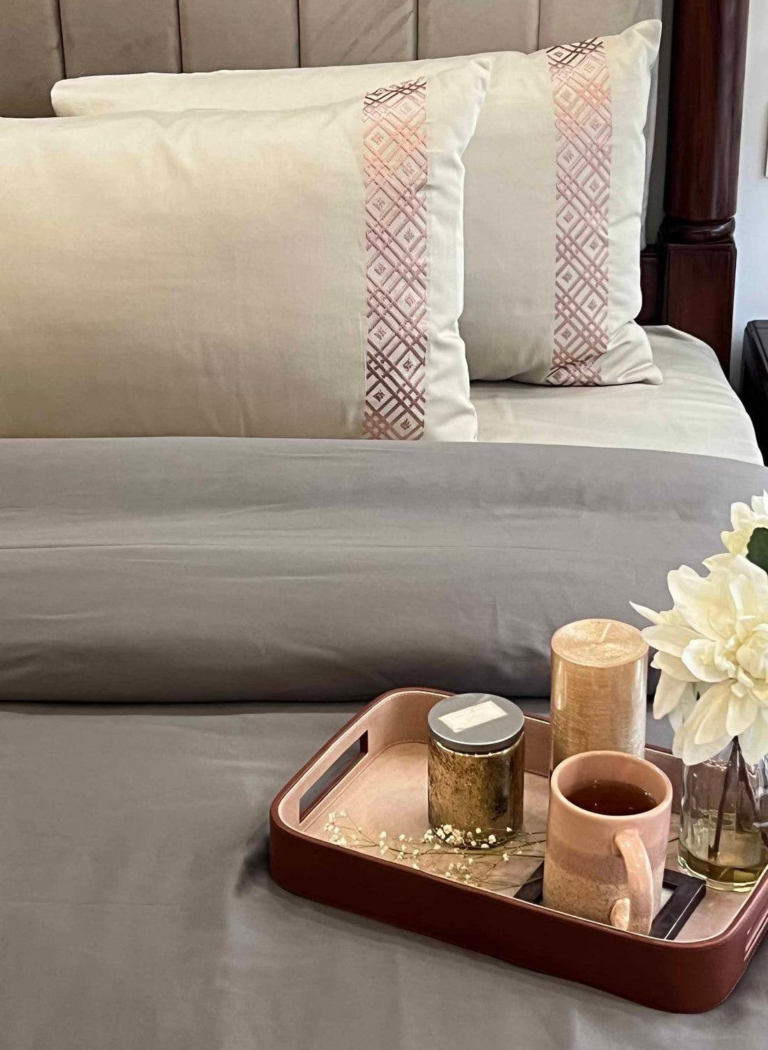 Cream embroidered-band pillows on grey bedding with a tray, Beige Classic Collection