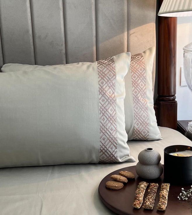Close up of a cream pillow with a rose embroidered band, Beige Classic Collection