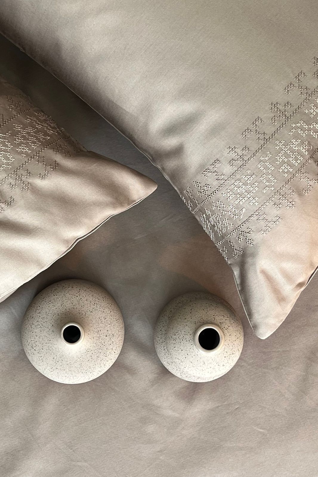Close up of greige sateen and an embroidered pillow edge, Greige Delight Collection