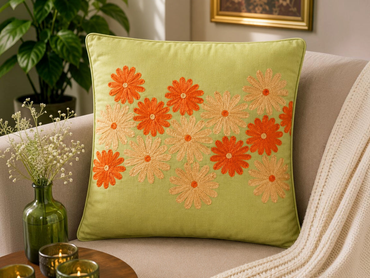 Jagdish Store lime green cushion cover with embroidered orange and gold floral pattern. Textured fabric.