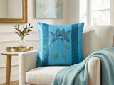 Jagdish Store embroidered decorative cushion cover in shimmering turquoise with teal, white, and gold floral embroidery and teal striped panels.