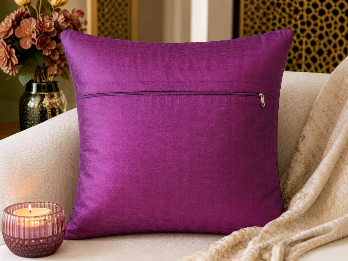 Purple pillow with a zipper on a beige couch with decorative elements.