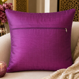 Purple pillow with a zipper on a beige couch with decorative elements.