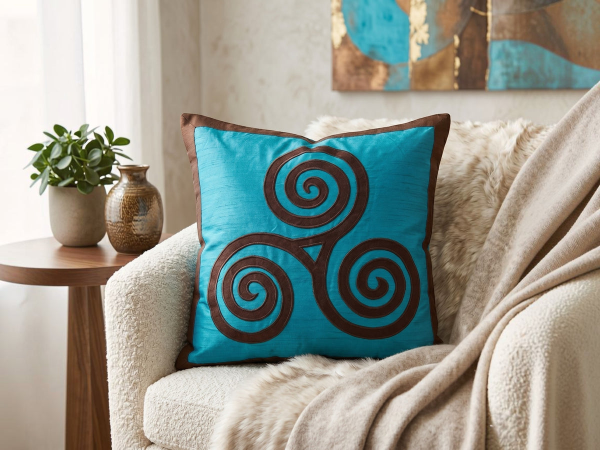 Jagdish Store turquoise cushion cover with a brown triskele spiral pattern and matching border.