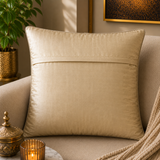 Jagdish Store decorative woven cushion cover in cream and gold with a subtle striped texture on a soft rug.