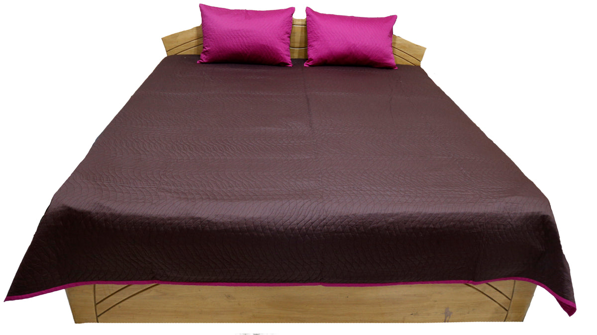 Aubergine quilted reversible bedcover with two magenta pillow covers, straight view