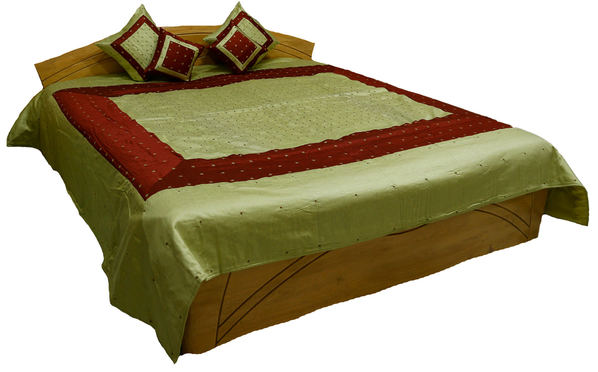 Pistachio green silk bedcover with maroon bands and mirror work dots, angled view