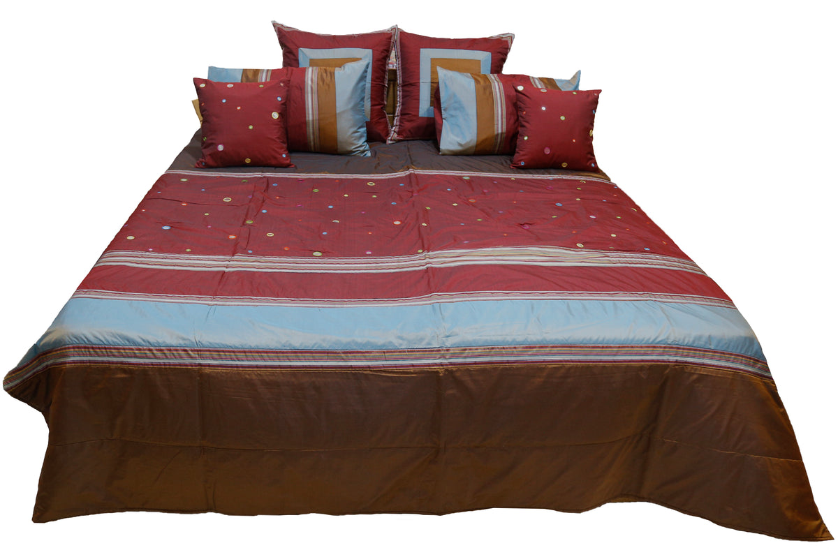 Maroon and brown bedcover with sky blue band and mirror work dots, straight view