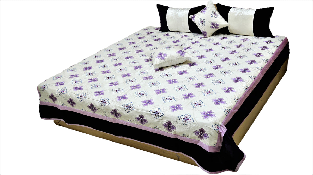 White quilted bedcover set with small purple flower motifs and black bordered pillow covers