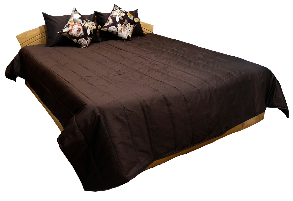 Chocolate brown silk bedcover with pintuck pleating and floral cushions, angled view