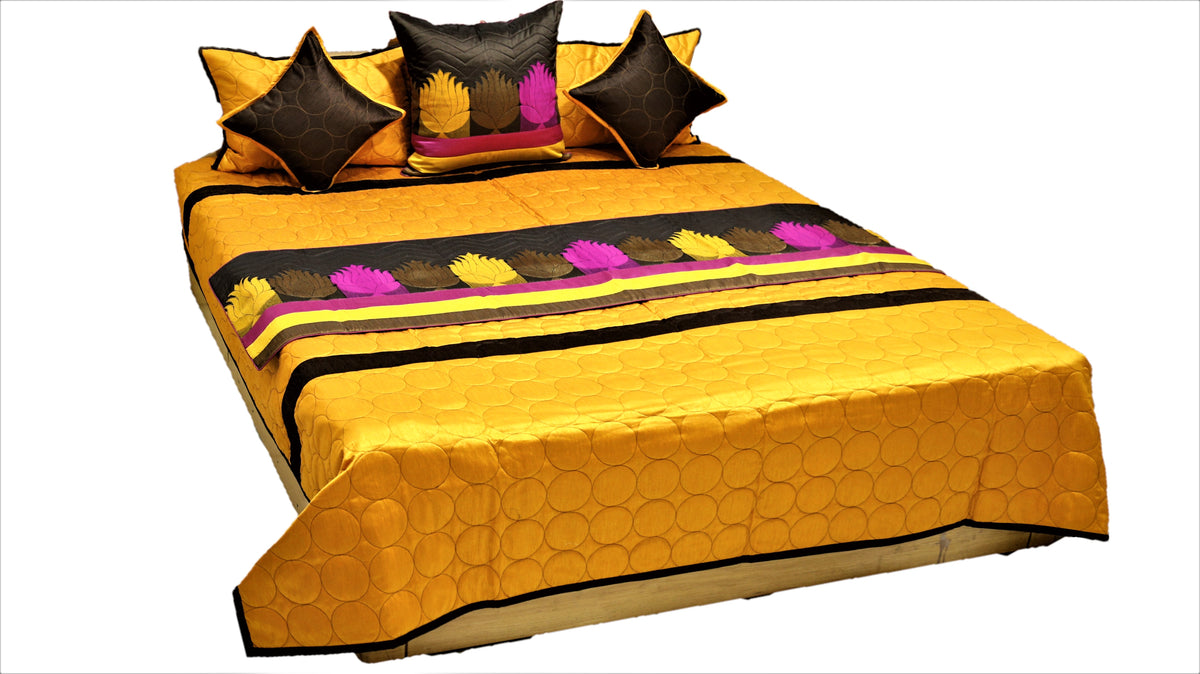 Marigold gold bedcover with circle quilting and lotus applique band, brown and pink cushions