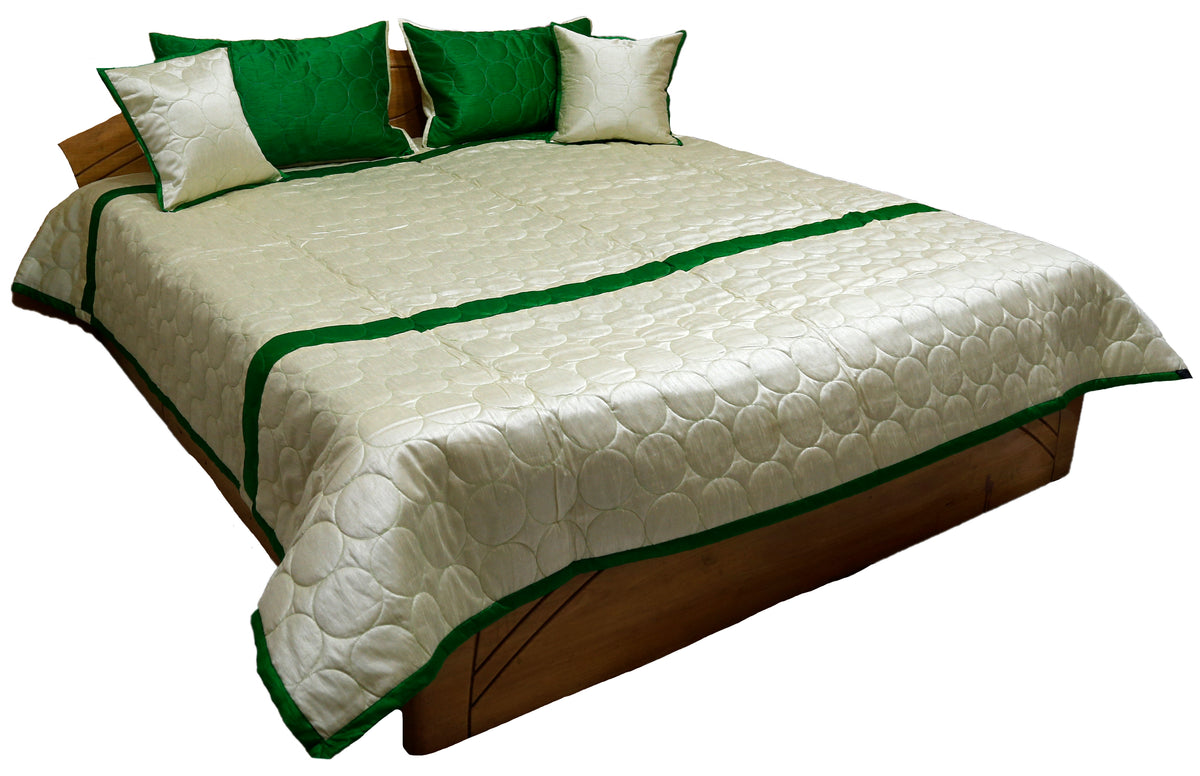 Ivory silk bedcover with circle quilting and green border, green and ivory cushion covers
