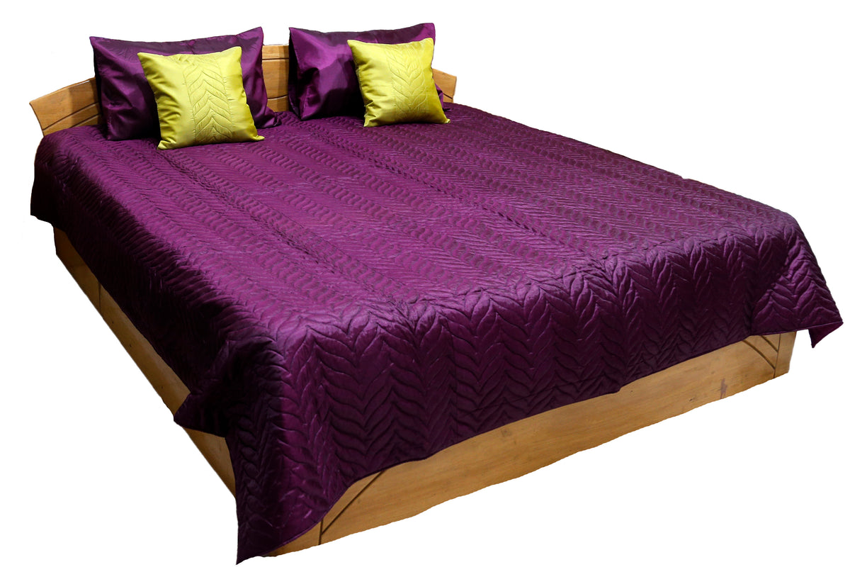 Deep purple embossed quilted double bedcover with matching purple pillow covers and chartreuse-yellow embossed cushion covers