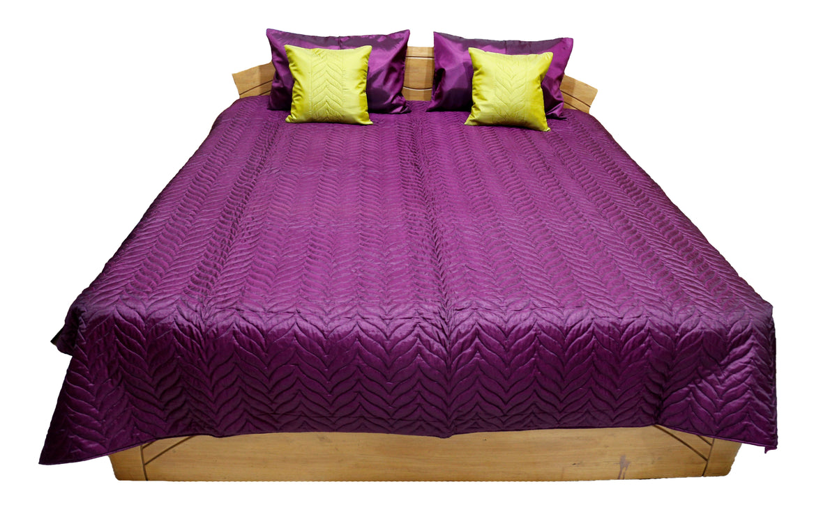 Deep purple embossed quilted double bedcover, angled view showing the chartreuse-yellow cushion covers