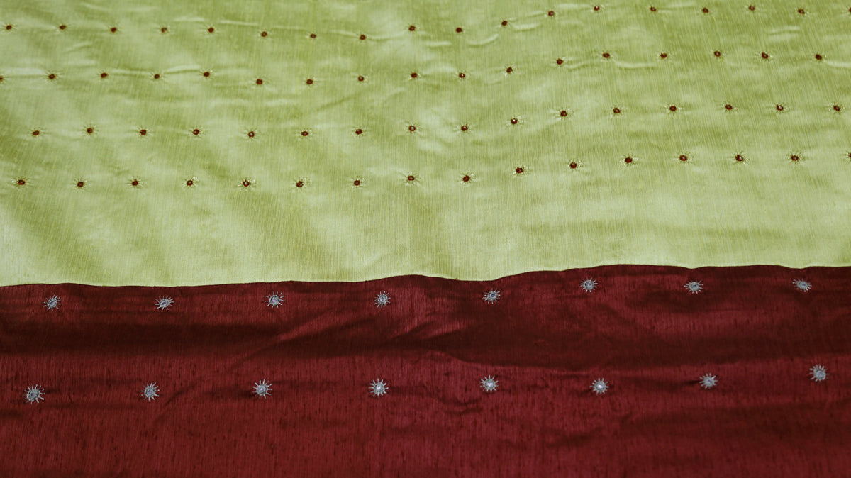 Close-up of gold and silver mirror work dots on pistachio green and maroon silk