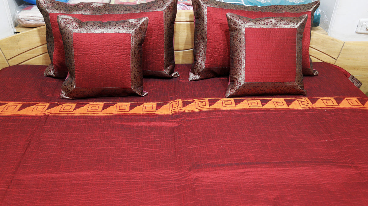 Close-up of the maroon cushion covers edged in a grey-brown brocade border