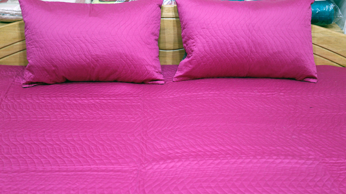 Close-up of magenta pillow covers on the magenta quilted side
