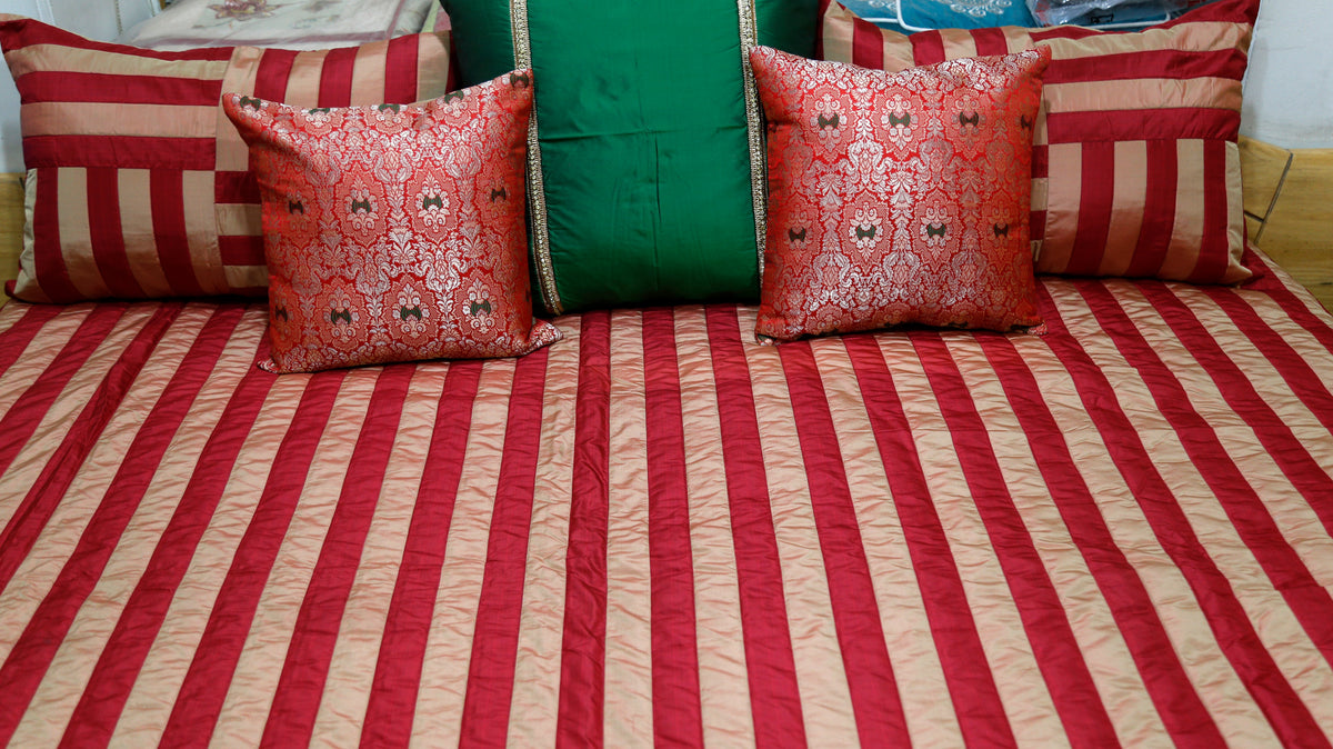 Close-up of the red damask-patterned cushion covers and green bolster pillow