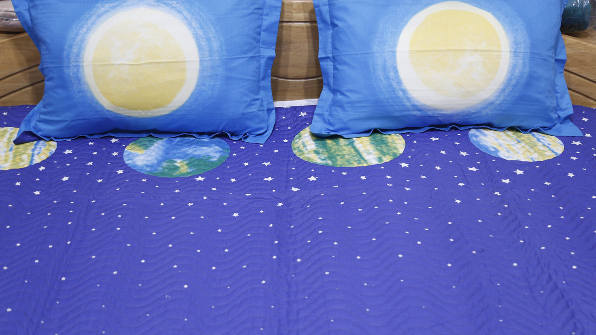 Close-up of moon print pillow covers on a starry blue children's bedcover