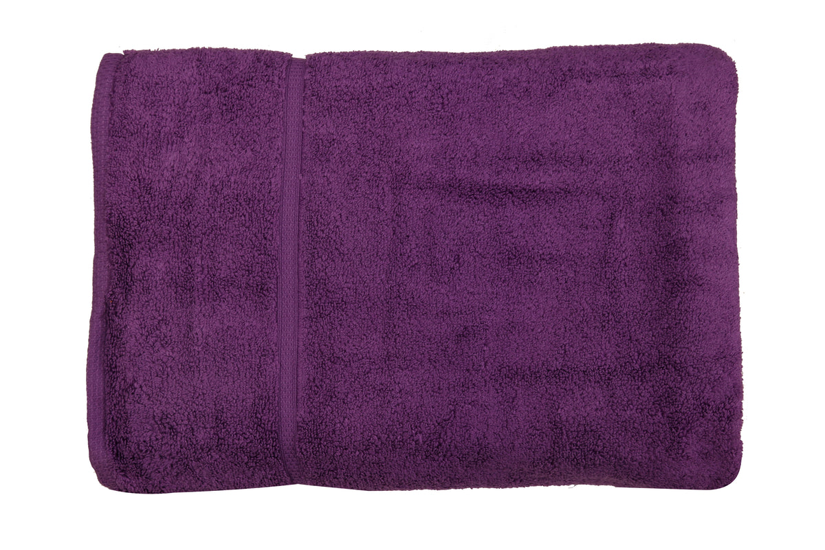 Deep purple cotton bath towel, close-up rolled view showing the woven dobby border